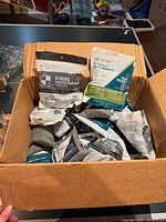 Box containing multiple sealed Powecom KN95 mask packs and grey deodorizer bags
