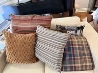 All six pillows grouped on white sofa showing patterns and colours