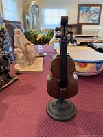 Front view of metal cello sculpture on pedestal