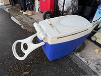 Overall view of blue Thermos cooler with tow handle extended