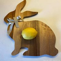full view of rabbit-shaped wooden cheeseboard with ribbon and lemon for scale