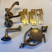 Overall group showing three lever handles, door knocker, five strike plates