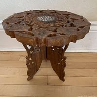 Assembled table front view highlighting carved top and legs