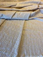 Folded yardage showing overall fabric and scalloped edge