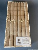 Full view of six rolled placemats in basket with label