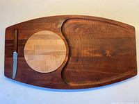 Top view of Baribocraft cheese board showing circular insert, crescent recess, and knife in slot