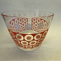 front view of clear glass ice bucket with orange and white circular pattern