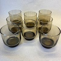 Eight smoky brown lowball glasses in two rows