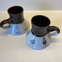 Both porcelain mugs showing overall shape, brown upper glaze and marine designs