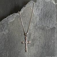Front view of sterling cross pendant on box chain