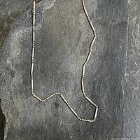 Full view of sterling silver necklace on slate background