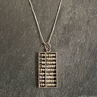 Pendant on chain full view against dark background