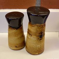 Front view of both ceramic shakers showing glaze colors and shape