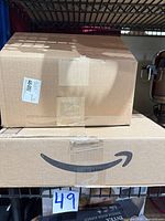 Two sealed Amazon shipping boxes containing cart components