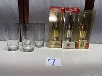 Group shot of all three boxed bottles and four etched glasses