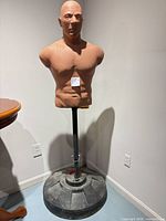 Full view of dummy on stand showing torso, pole and base