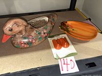 Ceramic duck planter, pumpkin dish and packaged adhesive hooks on tabletop