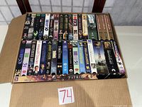 Box containing two rows of VHS tapes plus two horizontal tapes at front