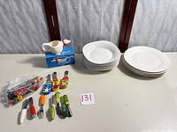 Group view of dinner plates, bowls, goose creamer and decorative utensils