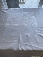 Full view of white linen damask tablecloth on surface