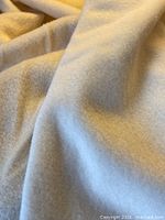 Close-up showing texture and pile of pale butter-cream wool fabric