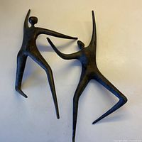 Two cast iron abstract human sculptures displayed together