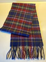 Full view of tartan scarf folded showing fringe and pattern
