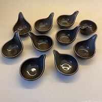 All ten olive green tear-drop bowls arranged