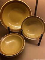 Full view of five mustard stoneware bowls displayed