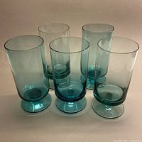 Full view of all five turquoise stemmed glasses standing upright