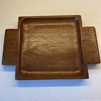 Top view of teak serving tray showing recessed interior and handle extensions