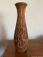 Full view of carved hardwood vessel standing on table