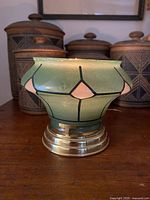 Front view lit candle showing glass shade and brass base