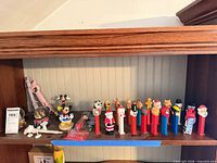 Shelf with full row of Pez dispensers and bottle openers
