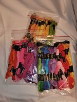 Three bags of assorted embroidery floss skeins in multiple colours