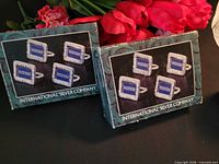 Two sealed boxes showing four place card holders per box