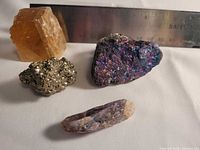 Group shot of four mineral specimens with ruler for scale