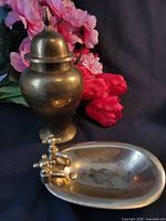 Brass ginger jar with lid beside brass soap dish shaped like tub