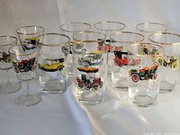 Twelve glasses grouped to show variety; gold rims and car motifs visible
