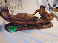 Full view of brown voyager canoe figurine