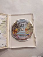 Open case showing disc artwork for The Many Adventures of Winnie the Pooh