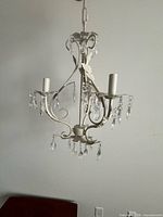 Full view of white 3-arm chandelier with crystals