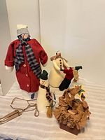 Group shot of three cloth snowmen and wooden basket on table