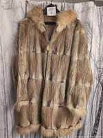 Front view of hooded sheared fox fur coat hanging