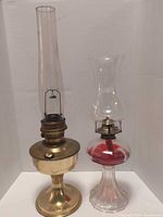 Two larger oil lamps, brass and glass types
