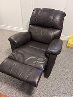 Full front view of brown leather recliner with footrest extended