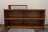 Front view of pine bookshelf with shelf insert resting at back