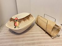Romertopf clay baker with lid beside Pyrex glass bread baker in metal cradle