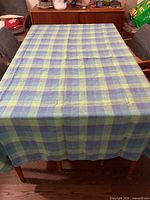 Blue-green plaid tablecloth spread on dining table