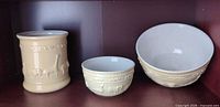 three-piece Williams Sonoma pale yellow ceramic set: utensil jar, small bowl, large bowl